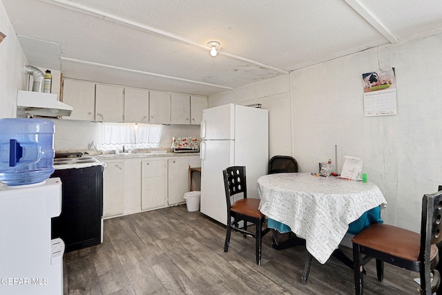 kitchen featuring hardwood / wood-style floors, white cabinetry, sink, white fridge, and electric stove