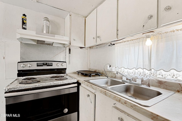 kitchen featuring electric stove, white cabinetry, and sink