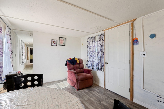 bedroom with hardwood / wood-style floors and a textured ceiling