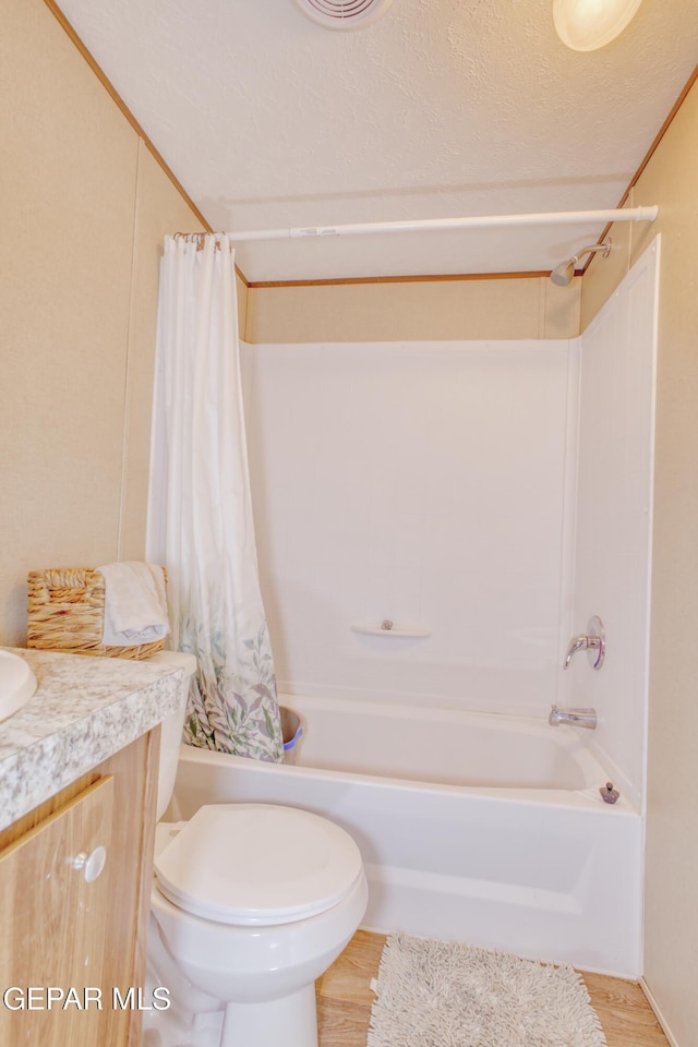 full bathroom featuring shower / tub combo with curtain, toilet, wood-type flooring, a textured ceiling, and vanity