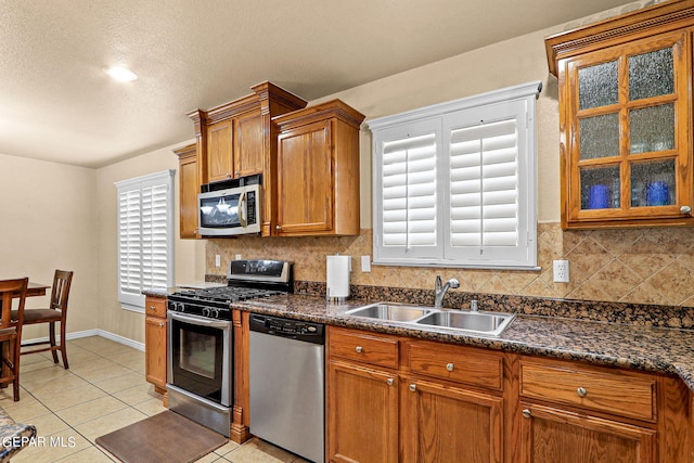 kitchen featuring stainless steel appliances, light tile patterned flooring, sink, and backsplash