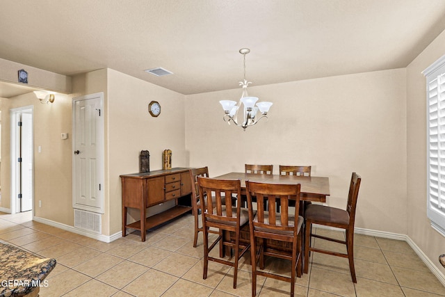 dining room featuring a chandelier and light tile patterned floors