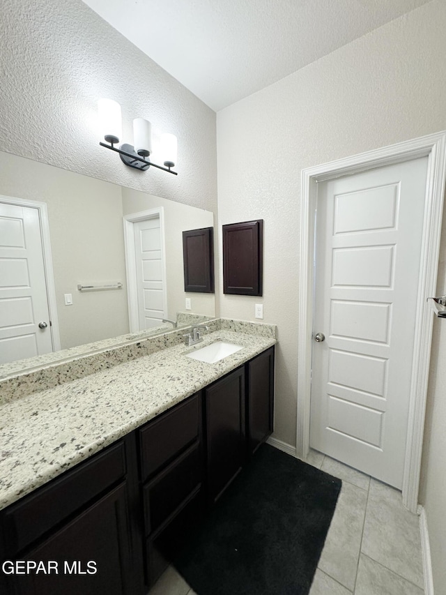 bathroom featuring vanity, tile patterned floors, and a textured ceiling