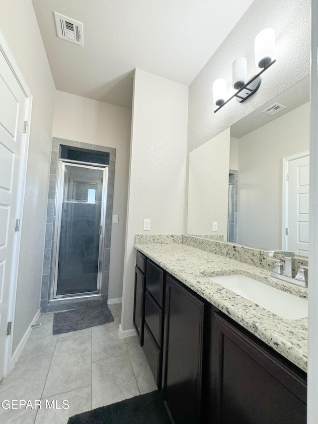 bathroom with vanity, tile patterned floors, and a shower with shower door