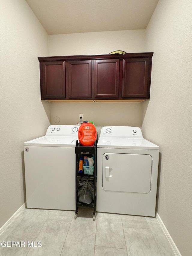 laundry area with washing machine and dryer and cabinets