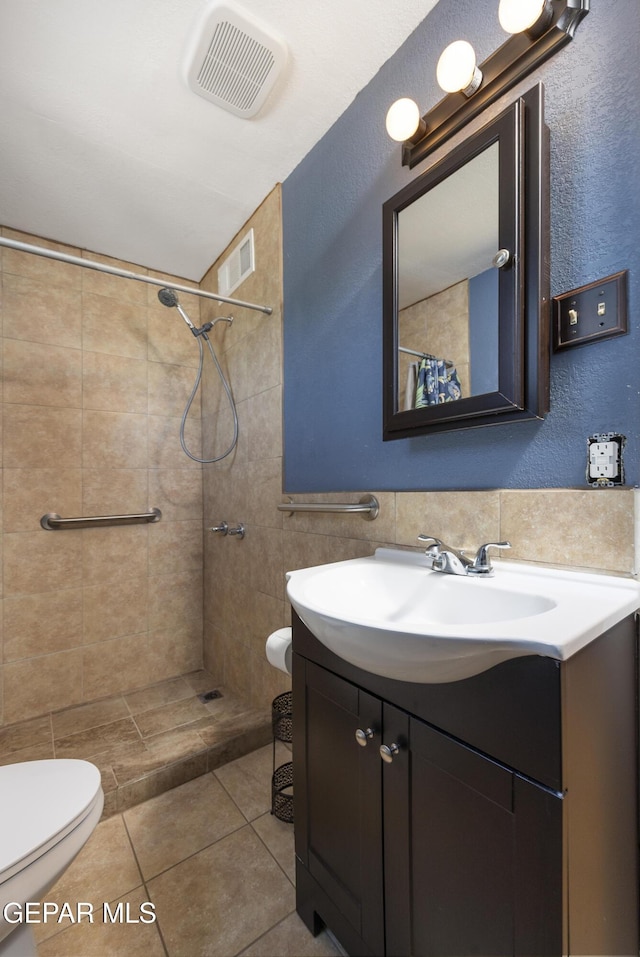 5047 Conley Rd, El Paso, TX 79932 - bathroom with tile patterned flooring, tile walls, vanity, curtained shower, and toilet