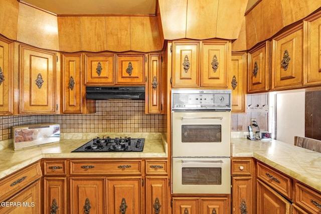 5047 Conley Rd, El Paso, TX 79932 - kitchen with tasteful backsplash, white double oven, black gas cooktop, and kitchen peninsula