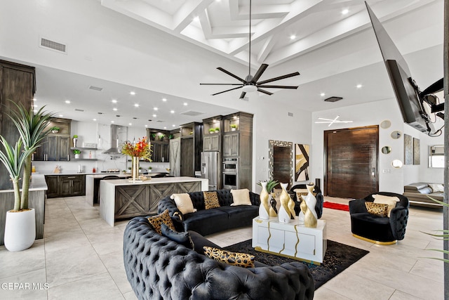 tiled living room featuring a towering ceiling and ceiling fan