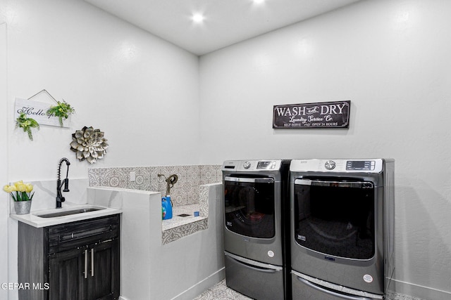 clothes washing area with sink, cabinets, and independent washer and dryer