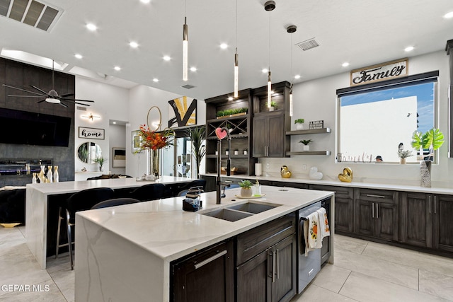 kitchen featuring an island with sink, sink, pendant lighting, and ceiling fan