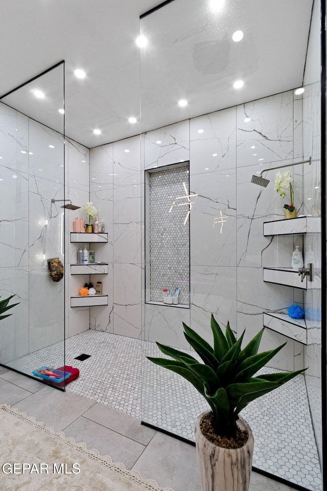 bathroom with a tile shower and tile walls