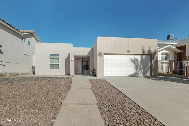 pueblo-style home featuring a garage and central AC