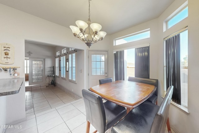 dining space featuring light tile patterned flooring and a chandelier