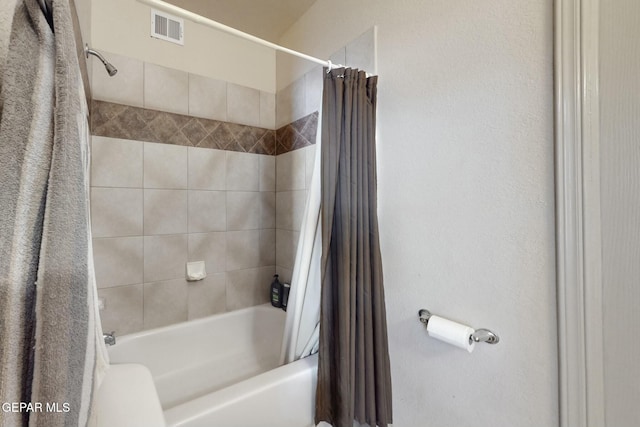 bathroom with visible vents and shower / tub combo with curtain