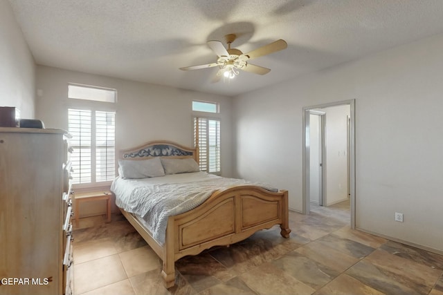 bedroom with a ceiling fan and a textured ceiling