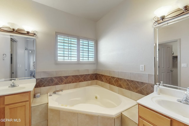 bathroom featuring tiled tub and vanity