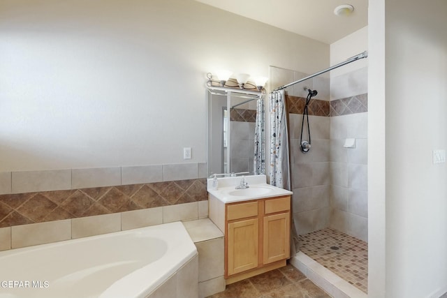 bathroom with a garden tub, tile patterned flooring, a shower stall, and vanity