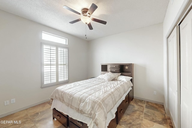 bedroom with ceiling fan, a closet, and a textured ceiling