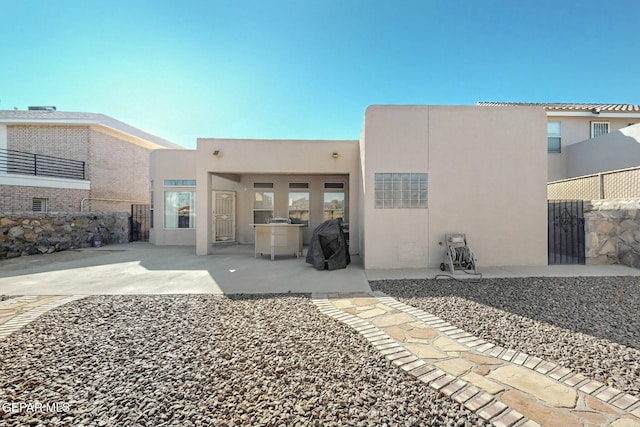 back of property featuring a patio, fence, and stucco siding