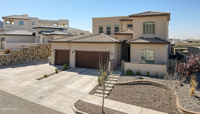 mediterranean / spanish-style home with fence, a tile roof, stucco siding, a garage, and driveway