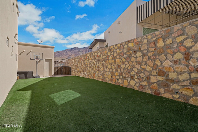 view of yard featuring a mountain view and fence