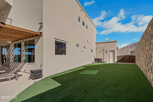 view of yard with a patio area, fence, and a mountain view