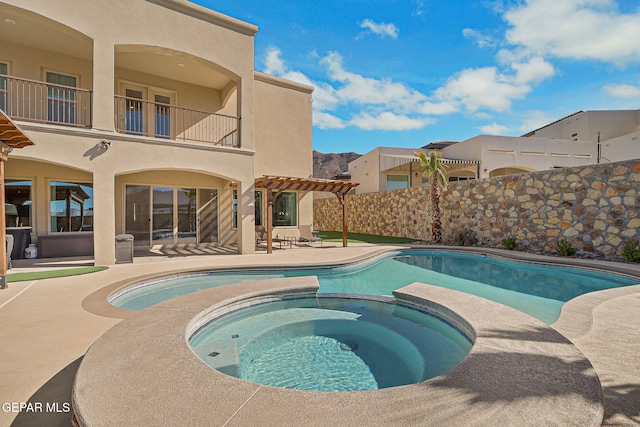 view of pool featuring a pool with connected hot tub, a pergola, and a patio area