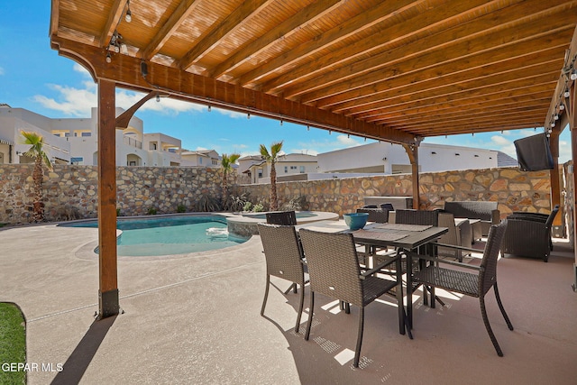 view of patio / terrace featuring outdoor dining space, a pool with connected hot tub, a fenced backyard, and a residential view