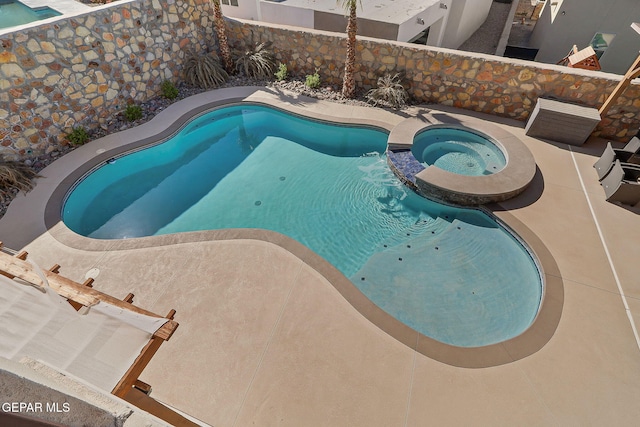 view of pool with a pool with connected hot tub and a patio area