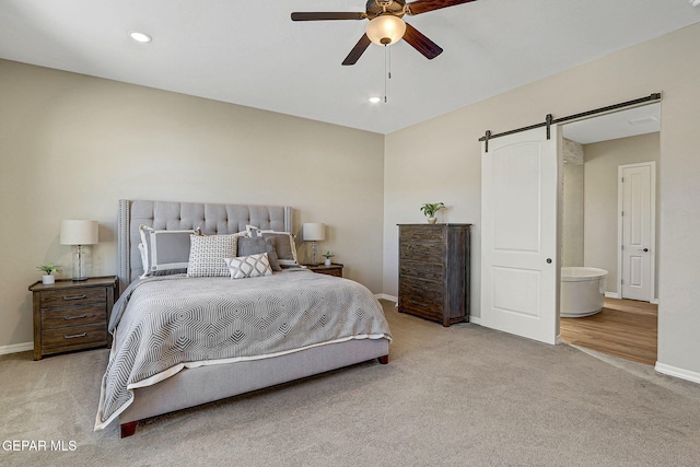 carpeted bedroom featuring baseboards, recessed lighting, ceiling fan, ensuite bathroom, and a barn door