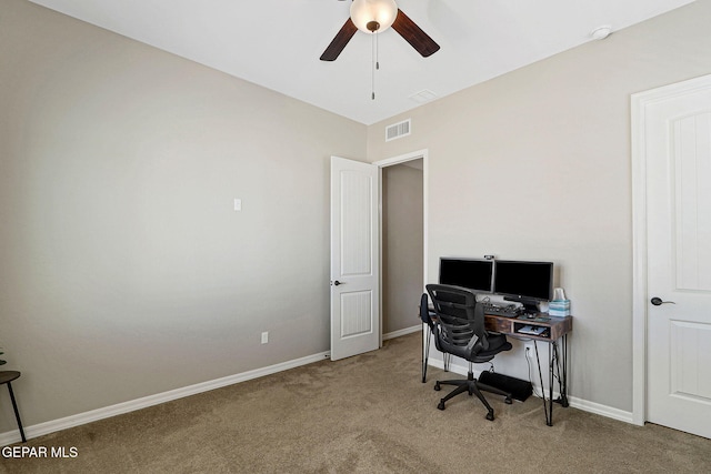 carpeted home office featuring a ceiling fan, visible vents, and baseboards