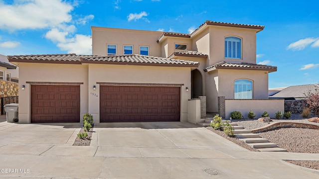 mediterranean / spanish-style house with a tile roof, stucco siding, an attached garage, and concrete driveway