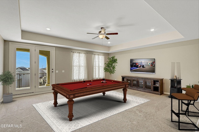 recreation room featuring pool table, a tray ceiling, a ceiling fan, and light carpet