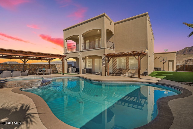 pool at dusk featuring cooling unit, fence, a pergola, a pool with connected hot tub, and a patio area