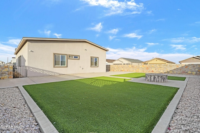 back of house featuring a patio area and a lawn