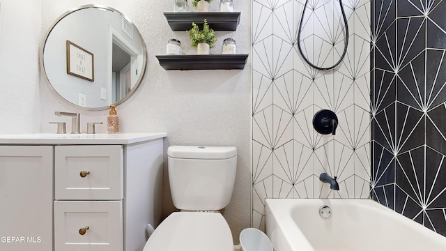 full bathroom with tiled shower / bath, vanity, and toilet