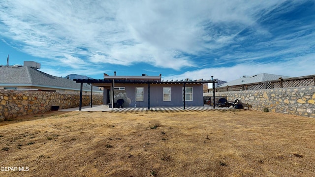 rear view of house with a lawn and a patio