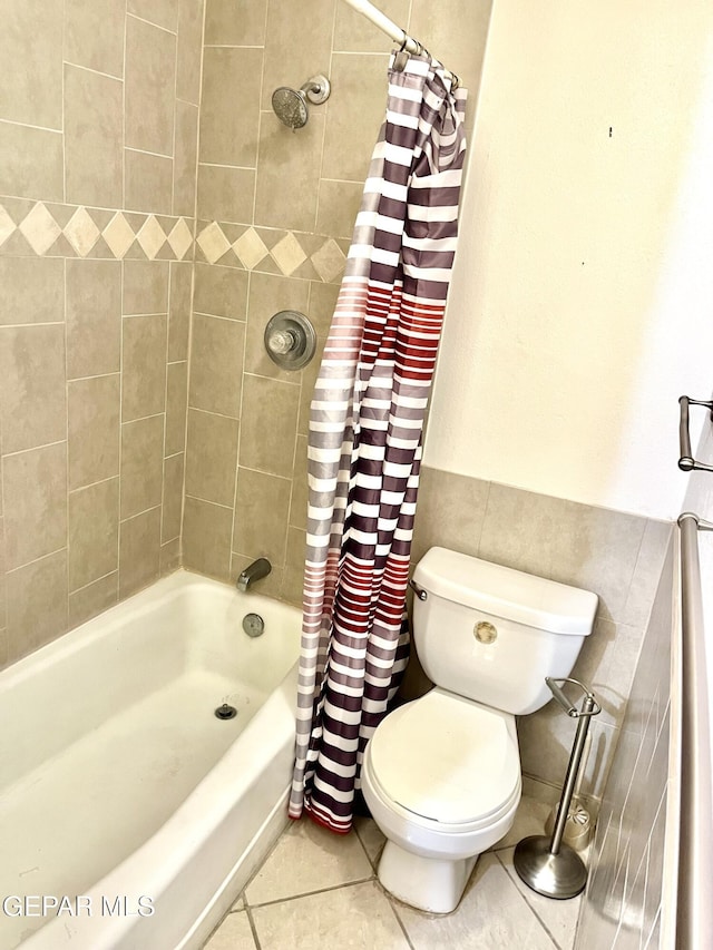 bathroom featuring shower / bathtub combination with curtain, tile patterned floors, and toilet