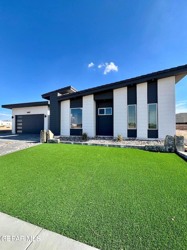 view of front of property with a garage and a front yard