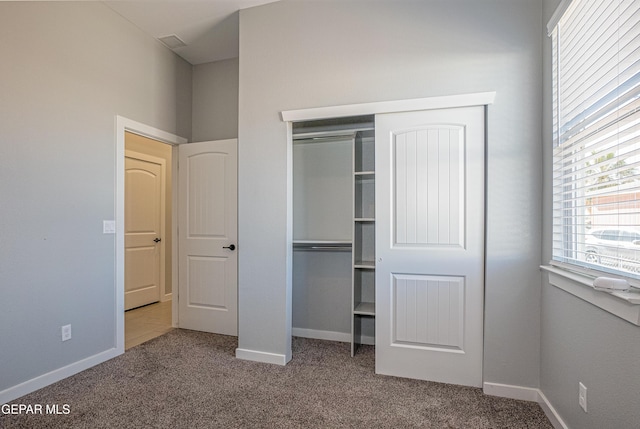 unfurnished bedroom featuring carpet flooring and a closet