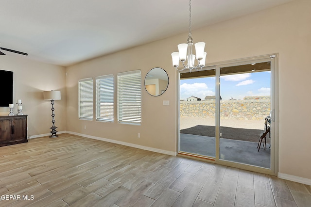 interior space featuring plenty of natural light and ceiling fan with notable chandelier