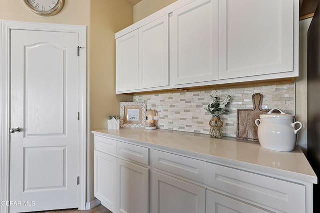 bar featuring white cabinetry and tasteful backsplash