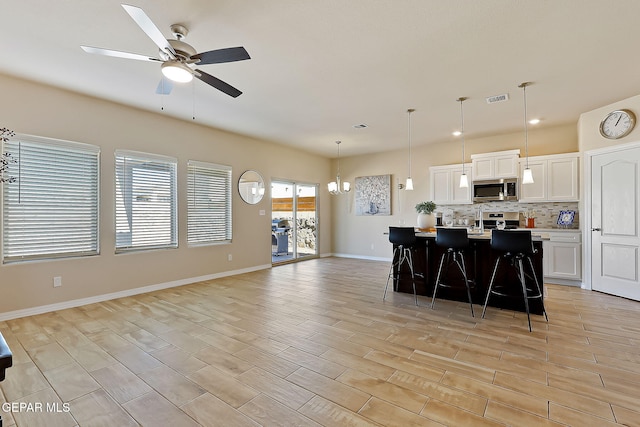 kitchen featuring appliances with stainless steel finishes, a breakfast bar area, a kitchen island, and white cabinets