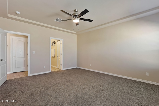 unfurnished bedroom with ensuite bathroom, light carpet, and ceiling fan