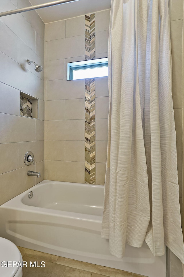 bathroom with toilet and shower / bath combo