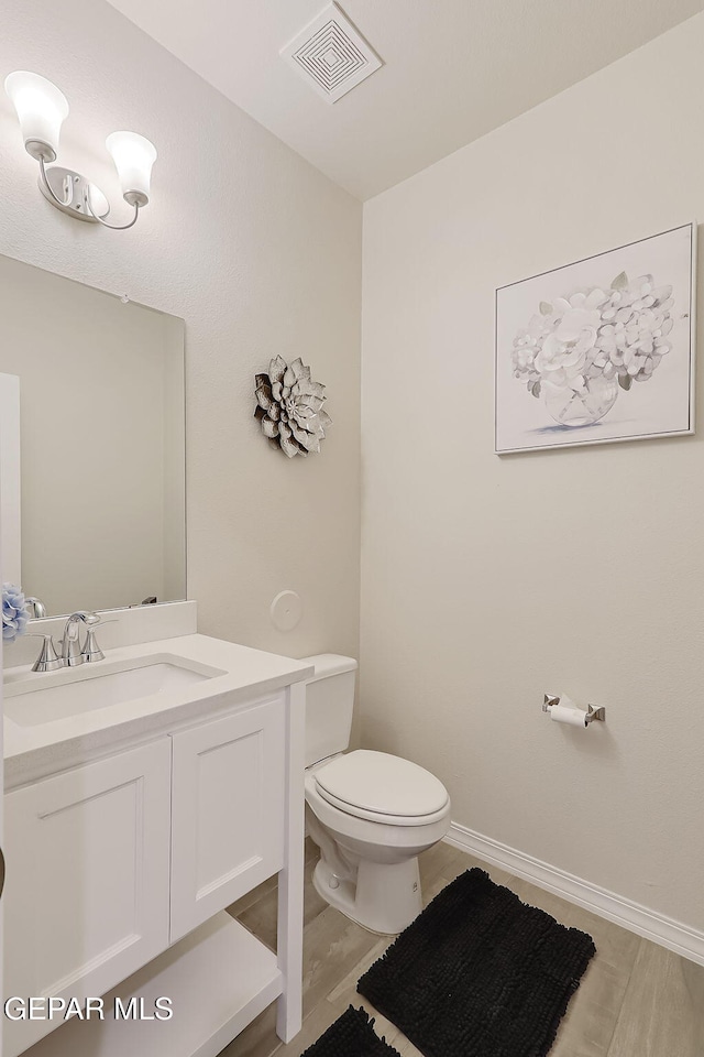 bathroom with vanity, wood-type flooring, and toilet