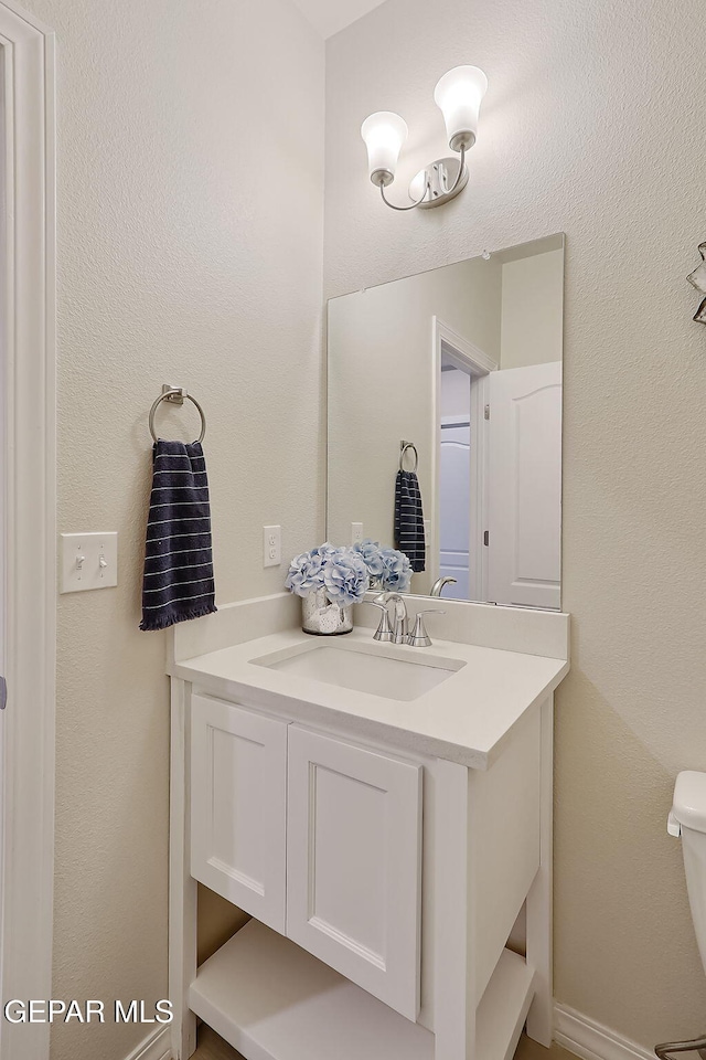 bathroom featuring vanity and toilet