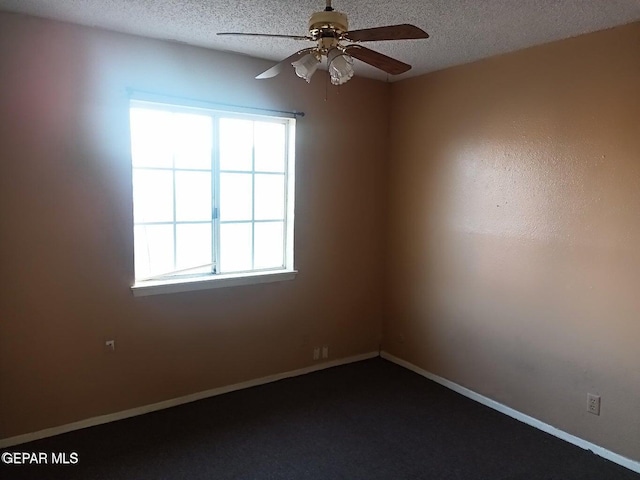 empty room with ceiling fan and a textured ceiling