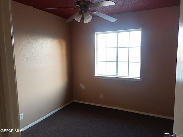 carpeted spare room featuring ceiling fan and a textured ceiling