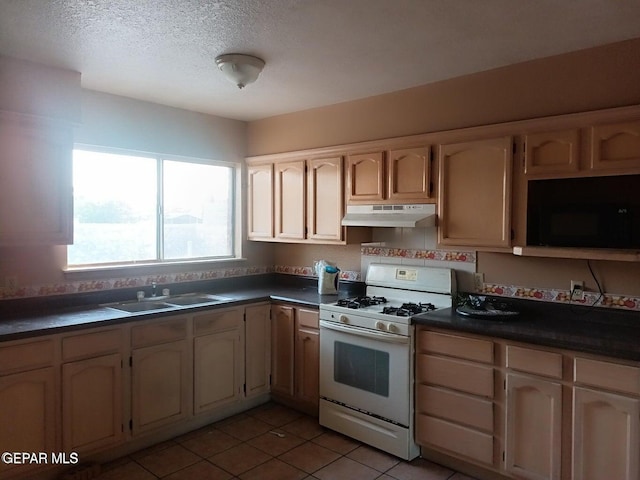 kitchen featuring sink, light tile patterned floors, white gas range oven, and a textured ceiling